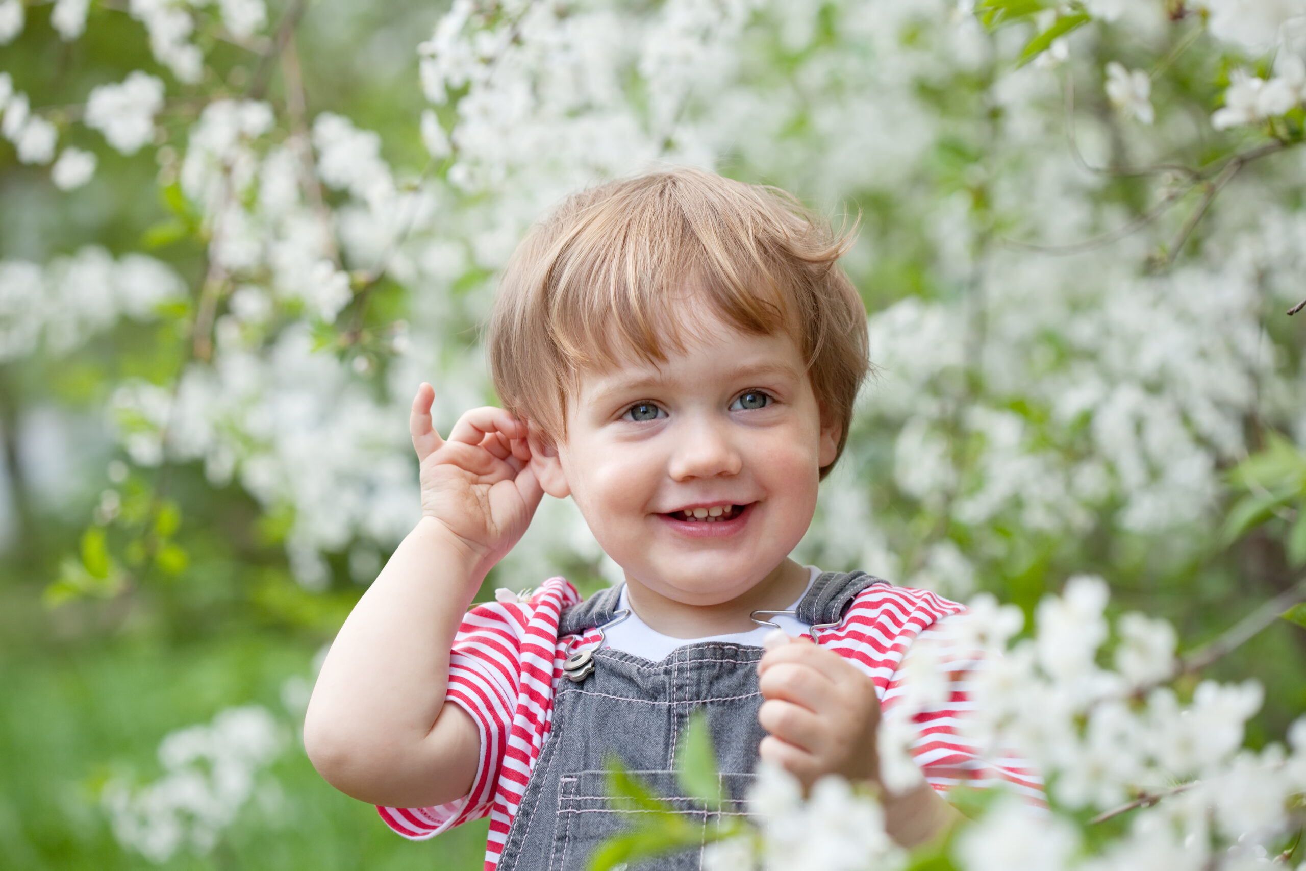 Happy  baby girl   against bloom garden